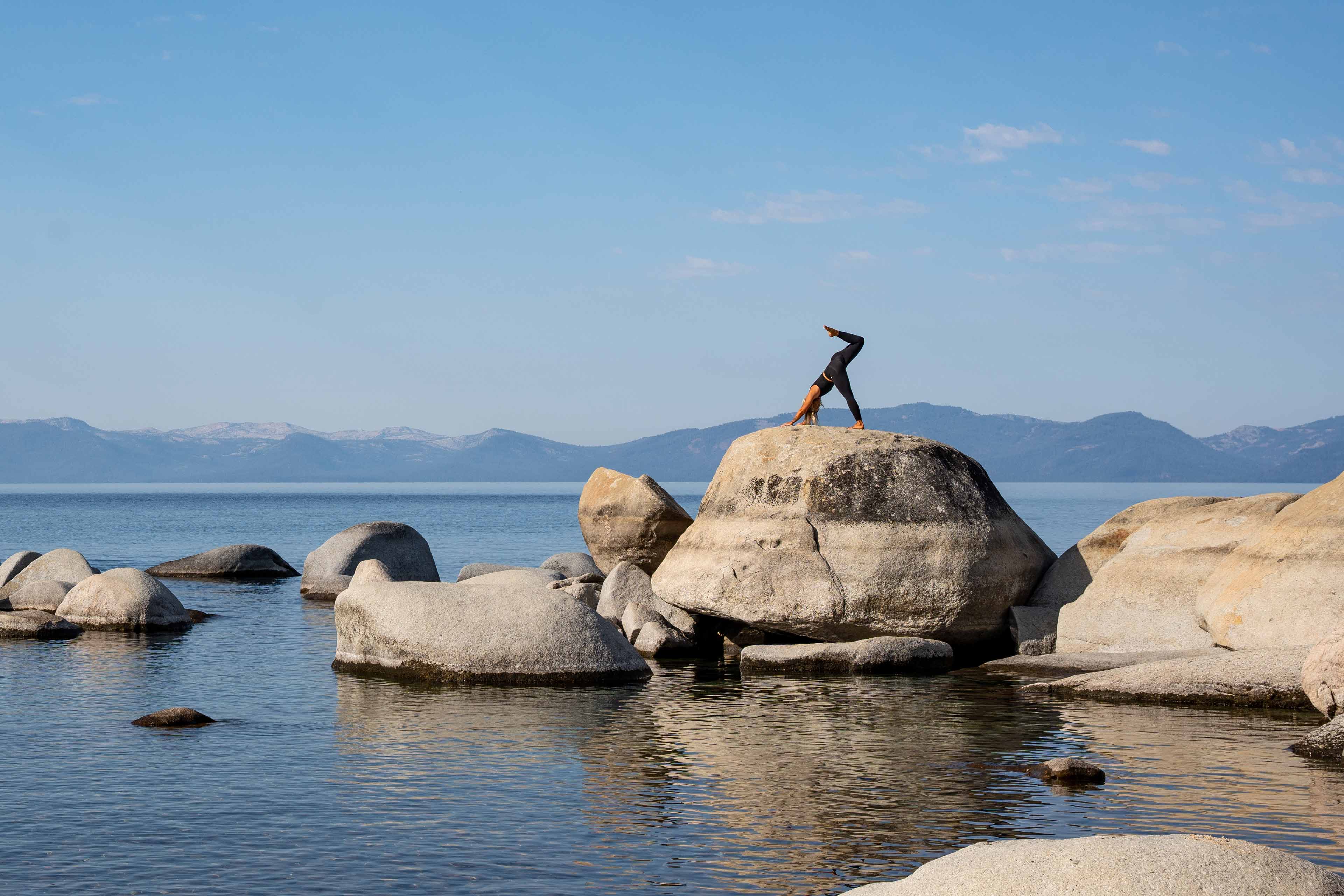 lady doing yoga in the top of a rock