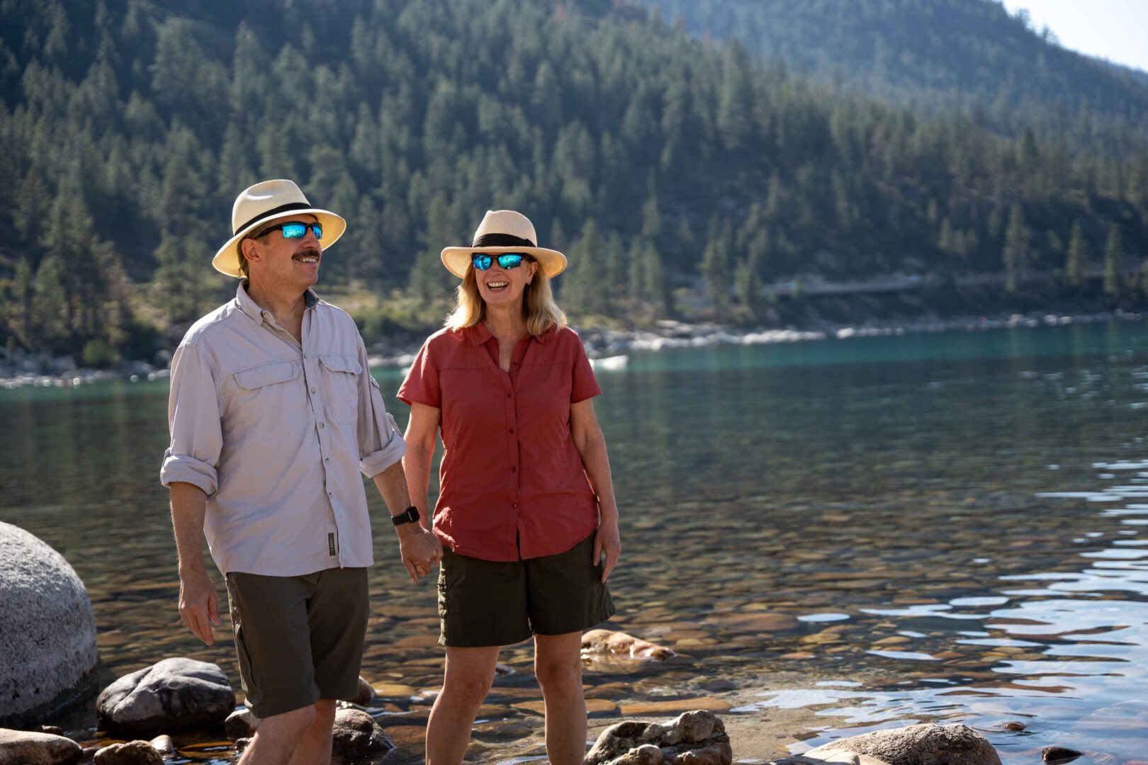 couple holding hands in the shore of the tahoe lake