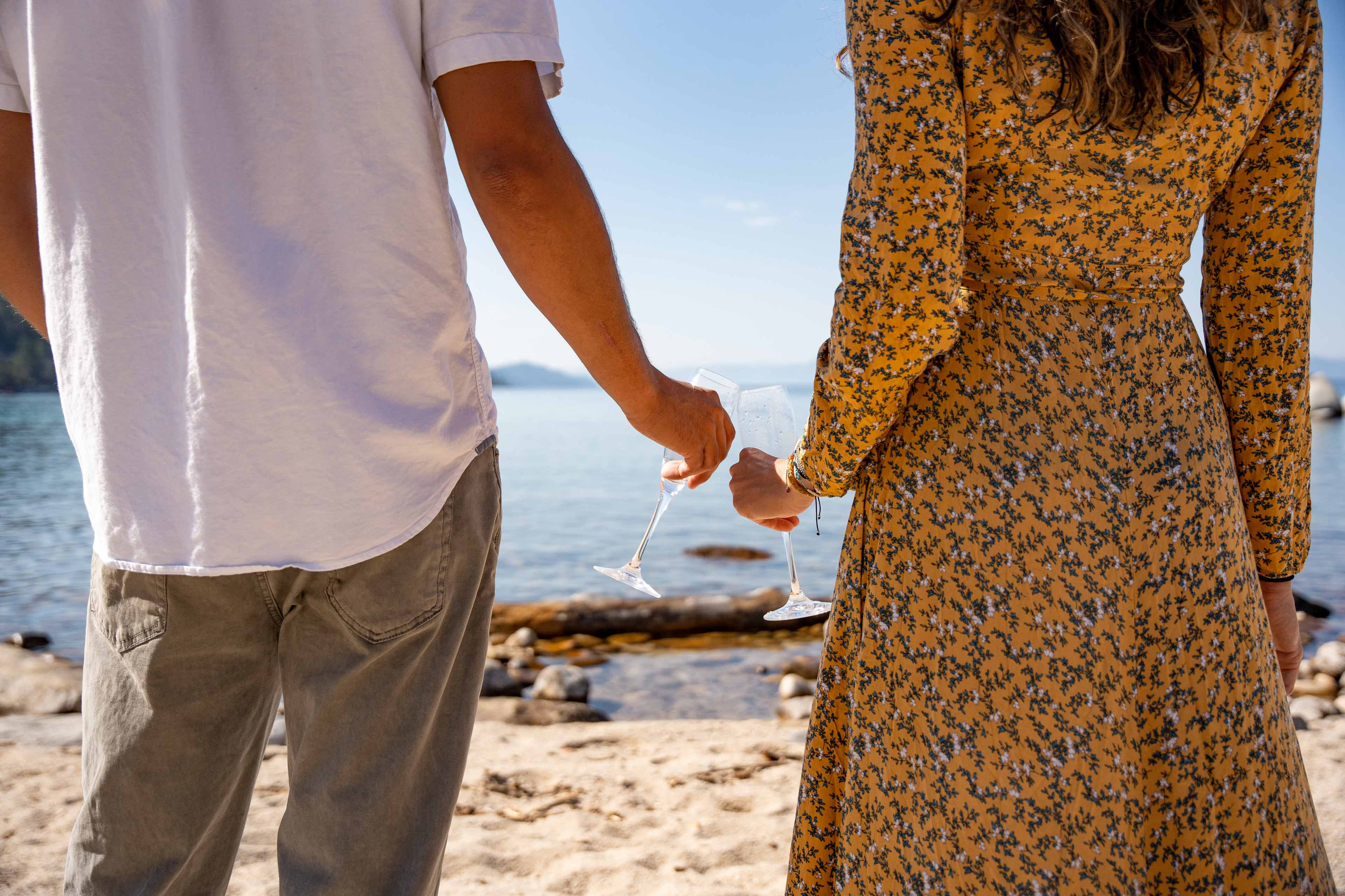 couple holding hands on the beach of the tahoe lake