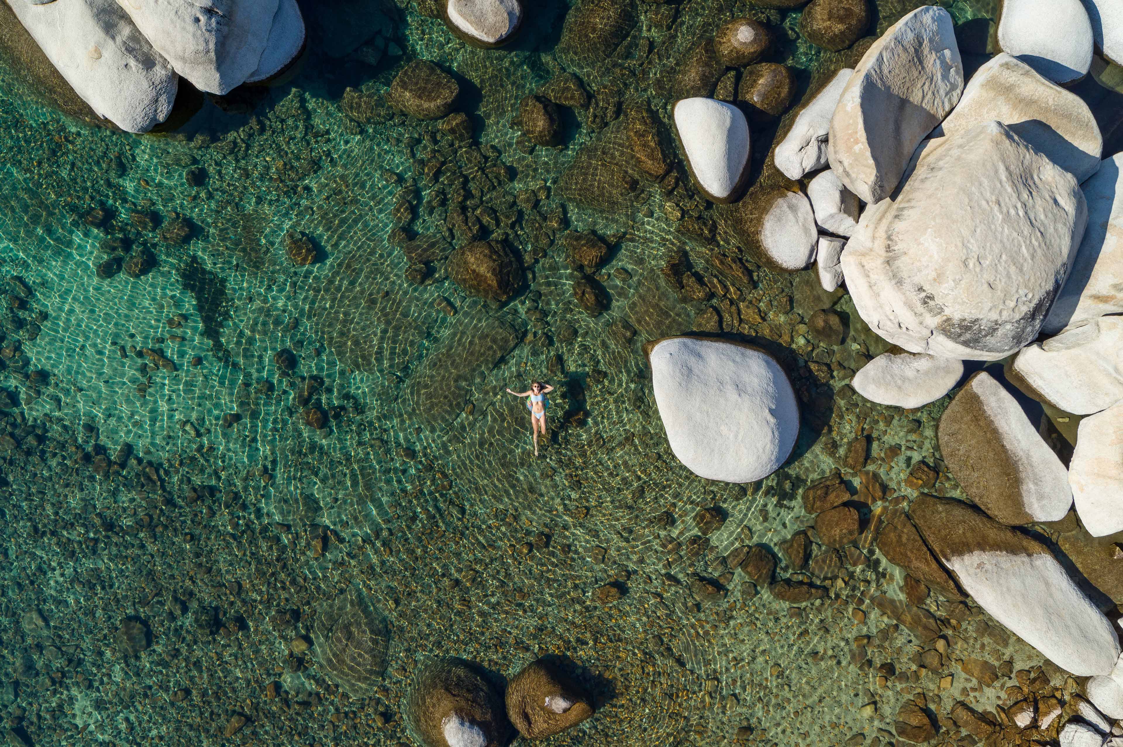 bird's eye view of woman swimming in pristine Lake Tahoe on a beach in Incline Village near Incline Lodge hotel